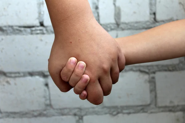 Brothers. The elder brother is holding a little boy by the hand