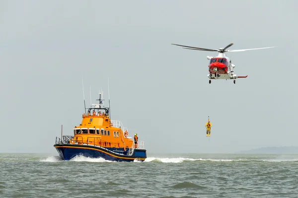 Orange sea rescue life boat with rescue helicopter