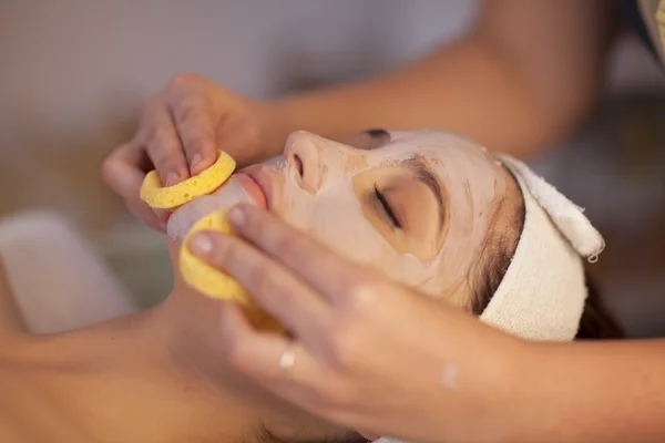 Cosmetician removing mask