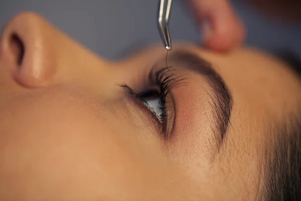 Woman putting artificial eyelashes on