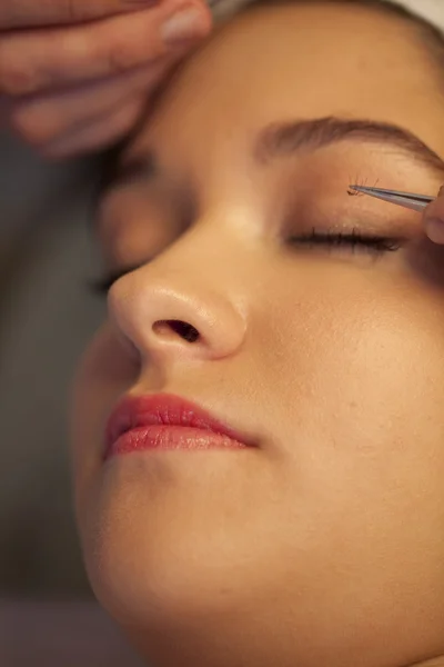 Woman putting artificial eyelashes on