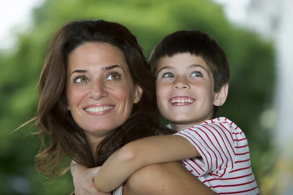 Mother giving son piggyback ride