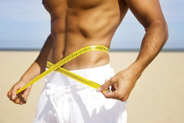 Man measuring waist with tape