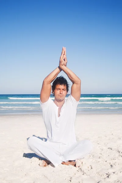 Man meditating on the beach