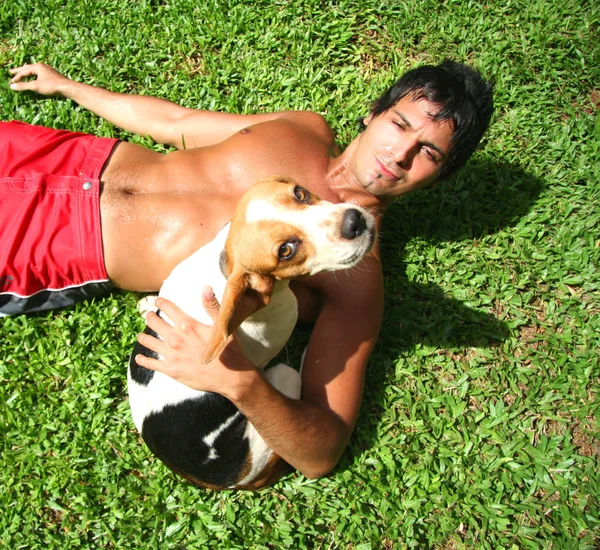 Man and dog lying on grass