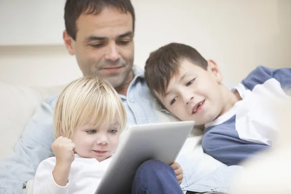 Family sitting on sofa with tablet