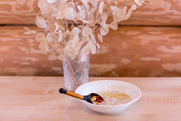 Porridge with butter and a wooden spoon out of focus in a wooden house