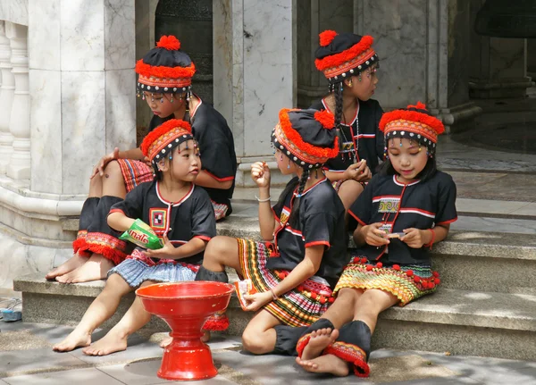 Unidentified hill tribe kids  relax from dance show for donation at Doi Suthep Temple, Chiangmai, north of Thailand.