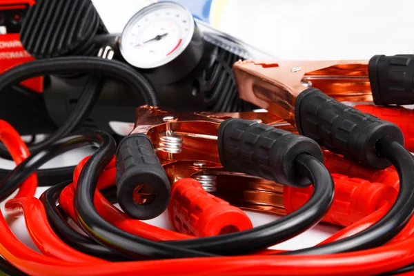 Starter cables and a pressure gauge for a car