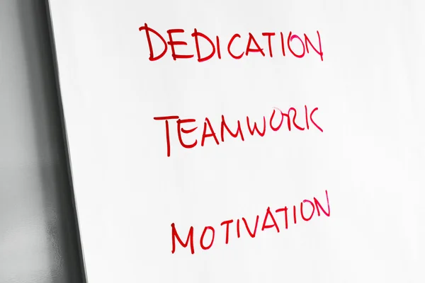 Dedication, Teamwork and Motivation words on paper