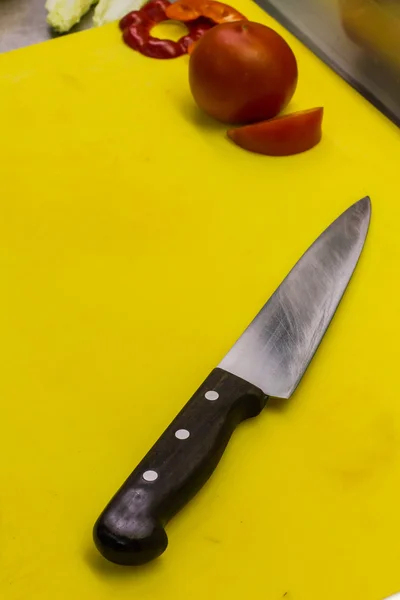Sliced tomato on cutting Board with knife