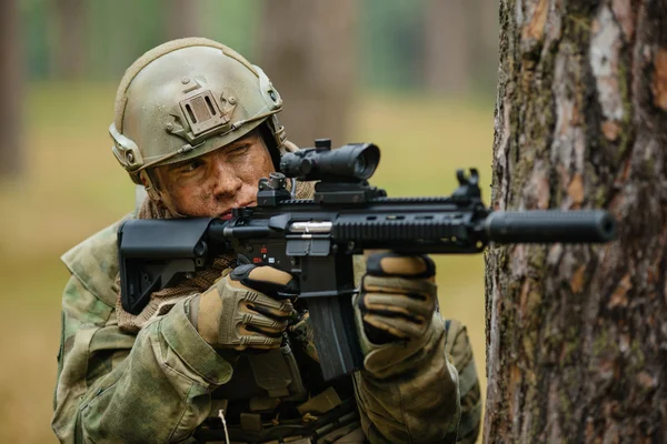 Soldier holding a gun aiming through the scope