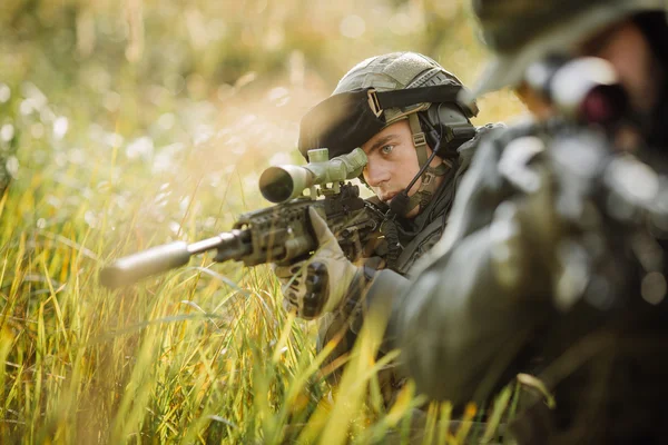 Military soldier shooting an assault rifle