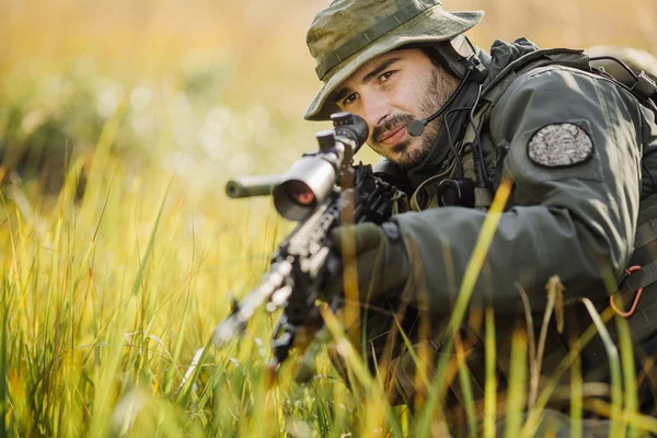 Military soldier aiming an assault rifle