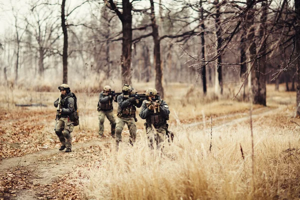 Soldiers with guns on the field