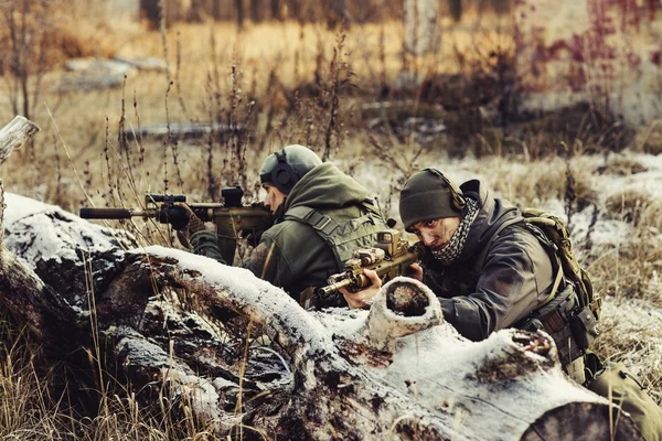 Two soldiers in an ambush aim at the enemy
