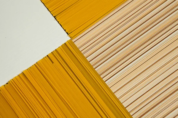 Spaghetti background. Yellow long spaghetti on black background. Thin pasta arranged in rows. Yellow italian pasta. Long spaghetti. Raw spaghetti wallpaper.