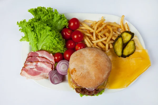 Fresh burger in plate with vegetables and french fries.Big hamburger. Ingredients for hamburgers. Top view