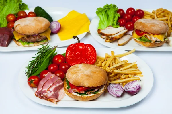 Fresh burger in plate with vegetables and french fries.Big hamburger. Ingredients for hamburgers. Top view