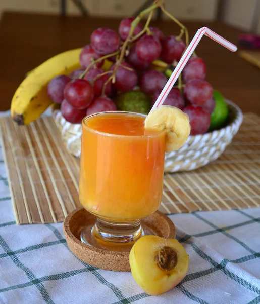 Healthy smoothie with orange, banana and apricot on a glass