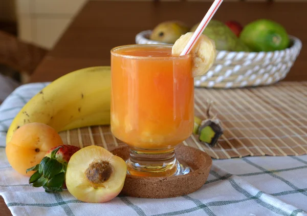 Fresh smoothie of orange, apricot and banana on a glass