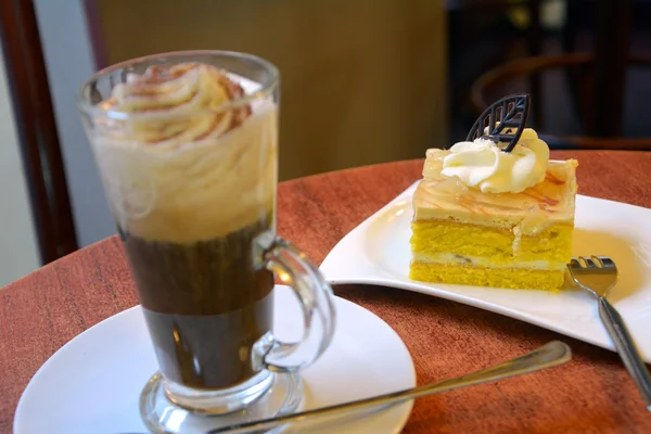 Slice of pear cream cake and cup of Viennese coffee