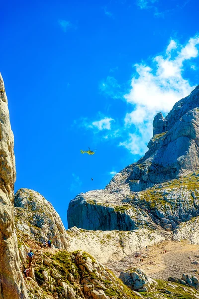 Rescue mission with helicopter in alpine mountain landscape.