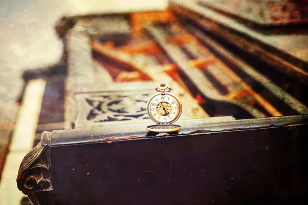 Vintage piano keys with antique pocket watch  time concept. vintage picture.
