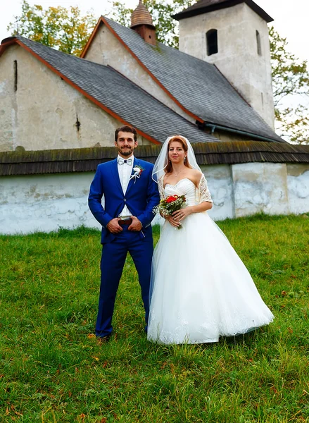 The bride and groom in front of a historical church.