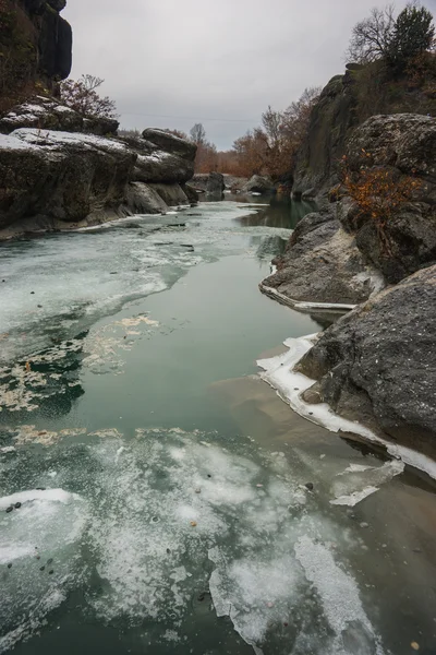 River with green waters, snow and ice near Meteora in Greece