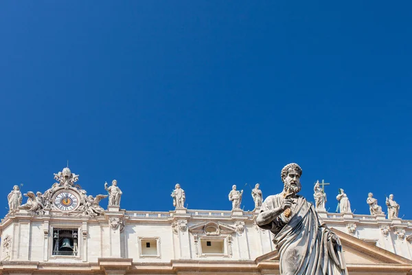 Statue of Saint Peter, St. Peter\'s Basilica and statues standing on the roof of St. Peter\'s Basilica on the background, Vatican.