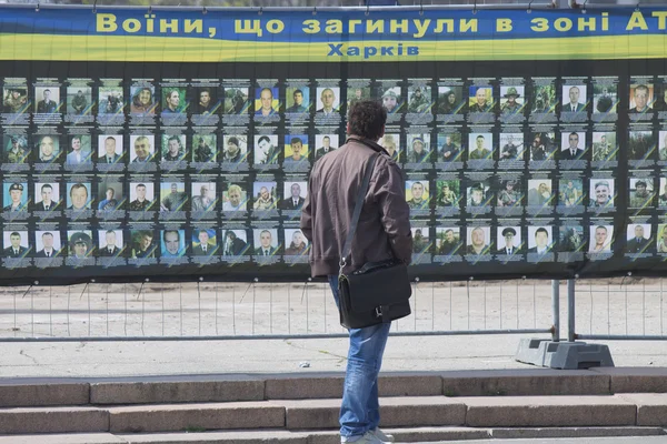 Residents of the city near the stand with photos of dead soldier