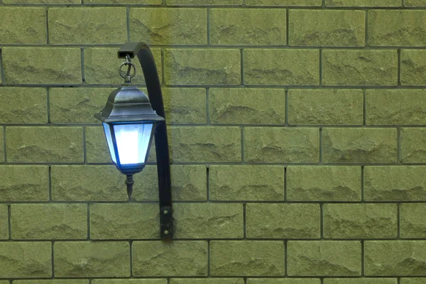 The lamp on a brick wall on the left