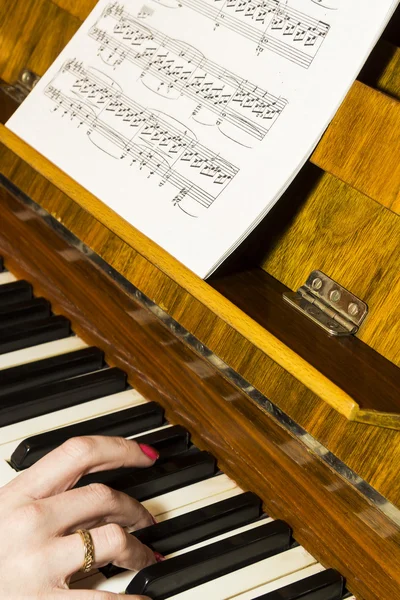 Girl playing the piano, female hands on the keys