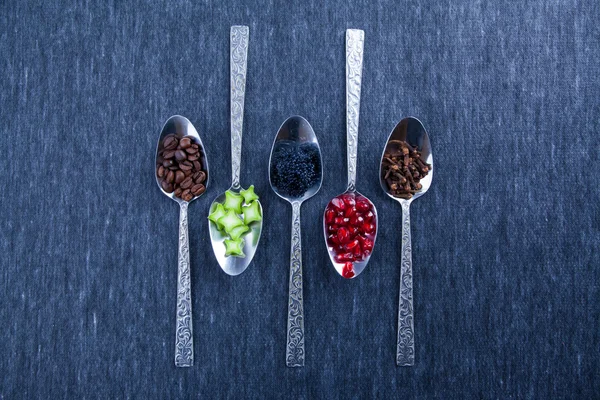 Five spoons with food and spices. Design, blue background. Caviar, garnet