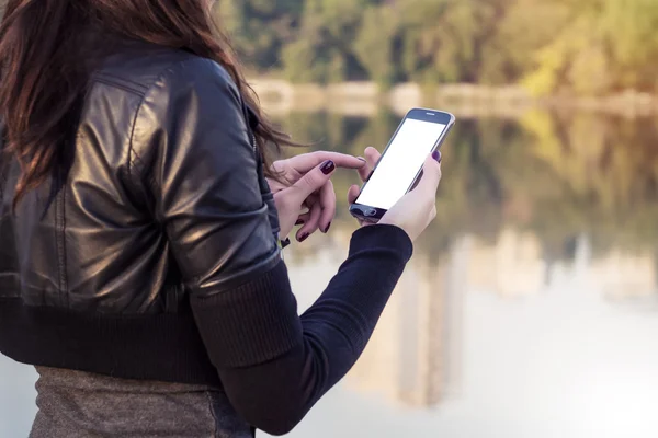 Young and attractive girl using modern smartphone with blank white screen