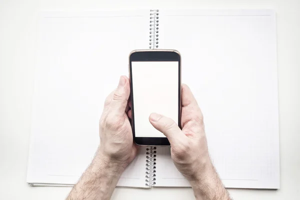 Man's hands with blank smartphone and diary, mock up