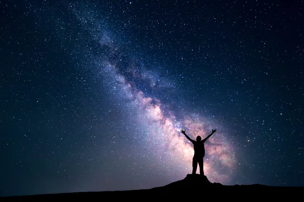 Landscape with Milky Way and silhouette of a happy man