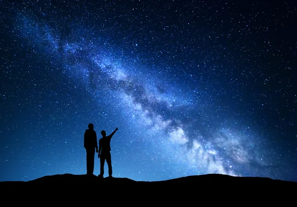 Landscape with Milky Way. Silhouette of a father and son