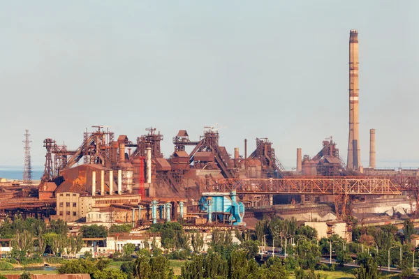 Steel factory with smokestacks at sunset. metallurgical plant. steelworks, iron works. Heavy industry in Europe. Air pollution from smokestacks, ecology problems. Industrial landscape
