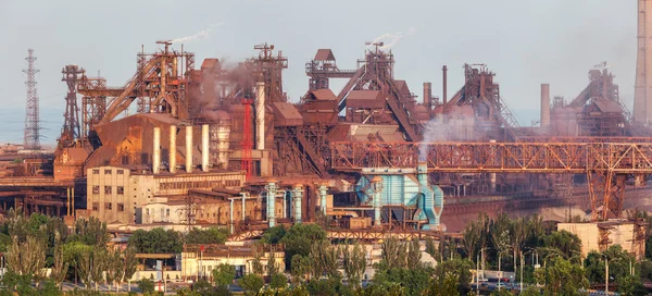 Rusty steel factory with smokestacks at sunset. metallurgical plant. steelworks, iron works. Heavy industry in Europe. Air pollution from smokestacks, ecology problems. Industrial landscape