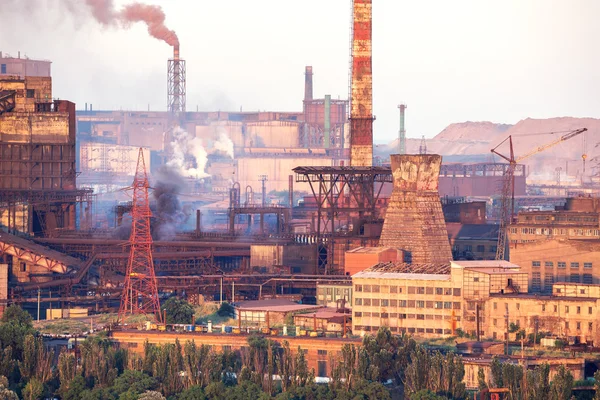 Industrial landscape in Ukraine. Steel factory with smog at sunset. Pipes with smoke. Metallurgical plant. steelworks, iron works. Heavy industry. Ecology problems, atmospheric pollutants.