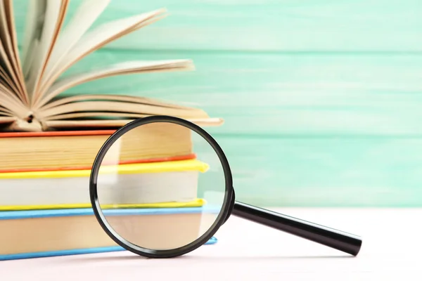 Magnifying glass with stack of books