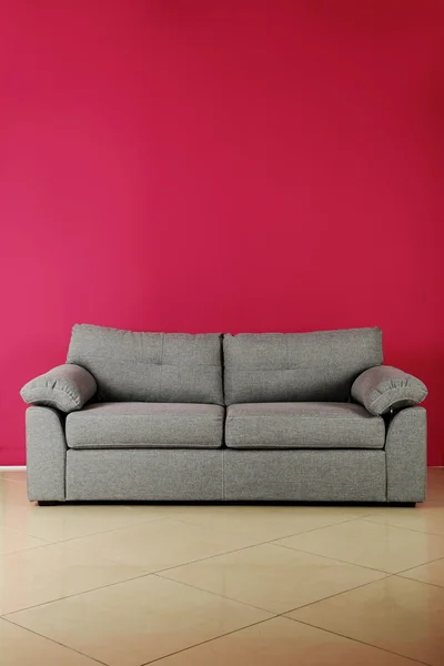 Grey sofa on a pink background