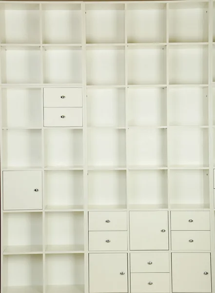 Empty shelves in white wooden rack