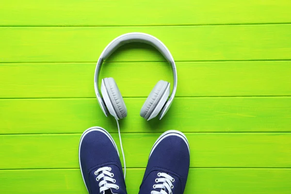 Headphones with shoes on a green table