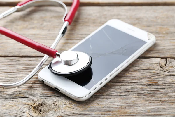 Broken smartphone with stethoscope