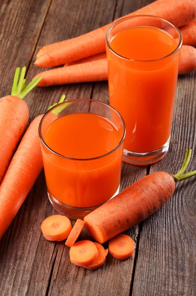 Glasses of carrot juice and carrots