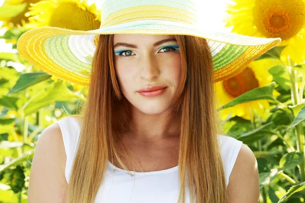 Beatiful girl with hat in the sunflowers field