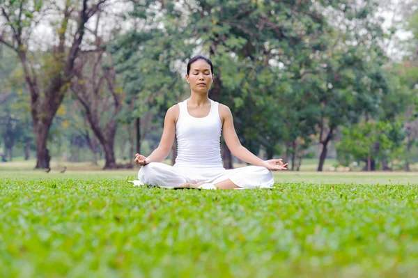 Beautiful woman practicing yoga in the park